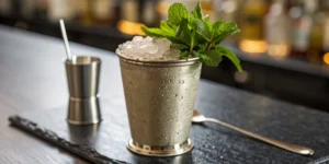 Bourbon mint julep recipe in a frosty silver cup with crushed ice and a mint garnish.